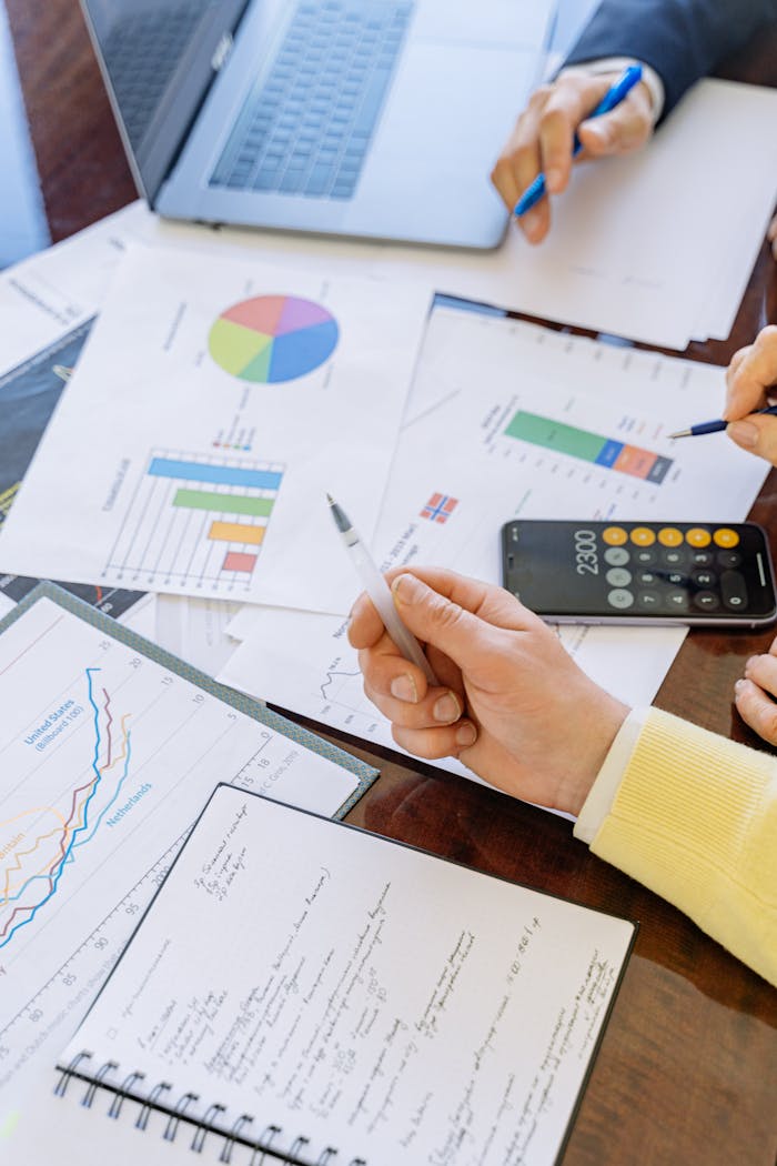 Mastering the First Impression: Your intriguing post title goes here A close-up of businesspeople analyzing financial data and charts during a meeting.